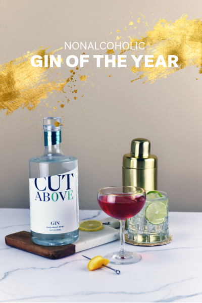 Bottle of 'Cut Above' nonalcoholic gin with a cocktail on a table, labeled as 'Gin of the Year'.