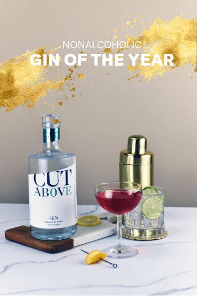 Bottle of 'Cut Above' nonalcoholic gin with a cocktail on a table, labeled as 'Gin of the Year'.